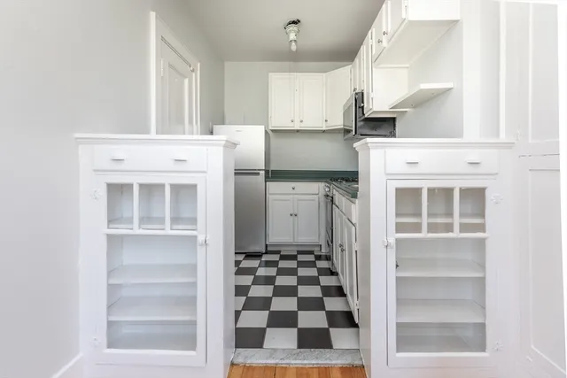 a kitchen with white cabinets and appliances