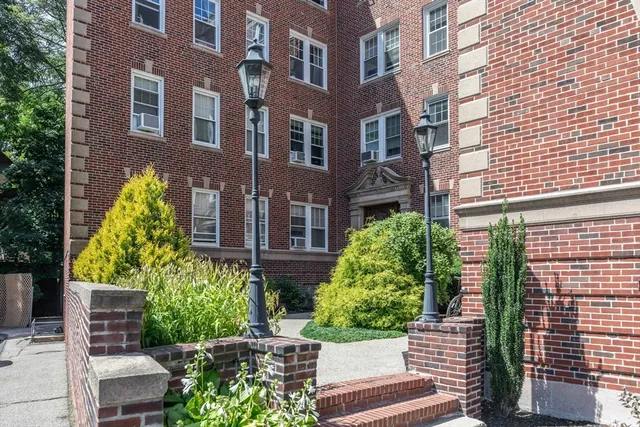 a front view of a multi story residential apartment building with a yard