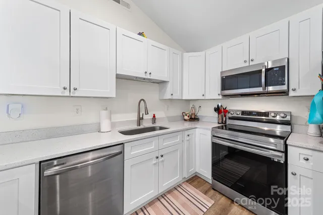 a kitchen with granite countertop a stove sink and cabinets
