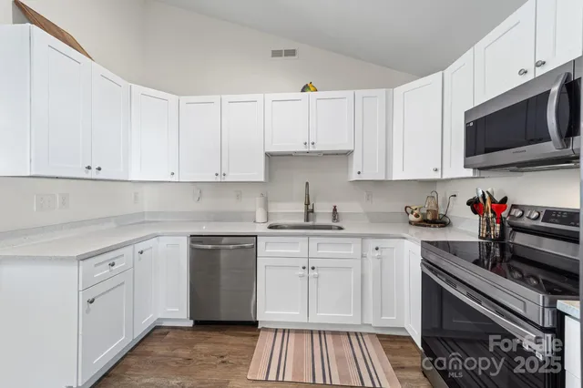a kitchen with cabinets appliances a sink and a counter top space