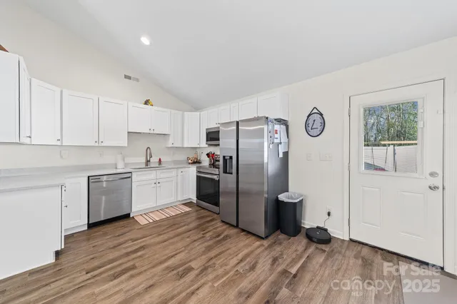 a kitchen with granite countertop a refrigerator and a stove top oven