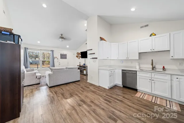 a large kitchen with kitchen island white cabinets and stainless steel appliances