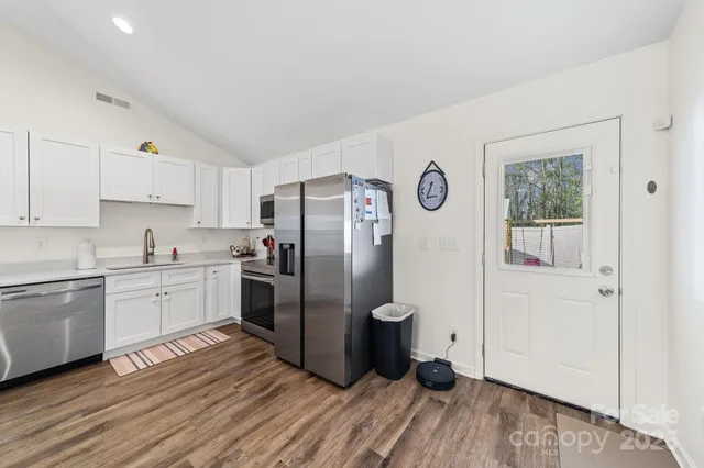 a kitchen with granite countertop a refrigerator and a stove top oven