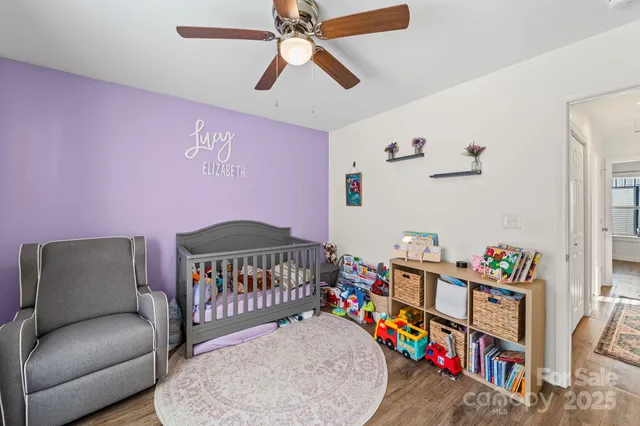 a bedroom with furniture a baby crib and a chandelier