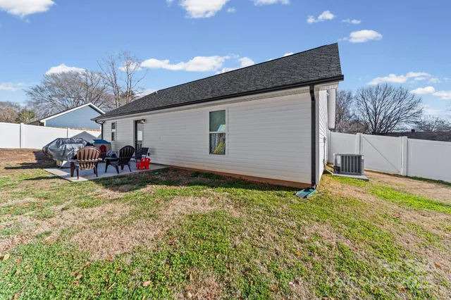 a backyard of a house with table and chairs