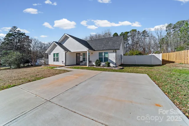 a front view of a house with a yard and trees