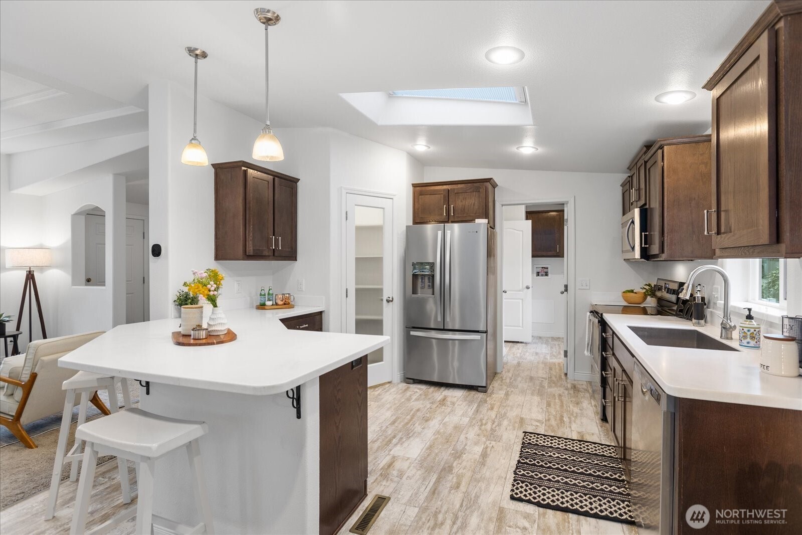23825 15th Avenue Southeast, Unit 169 Bothell, WA 98021 - Photo 11 of 25 a kitchen with stainless steel appliances granite countertop a sink a stove a refrigerator cabinets a dining table and chairs