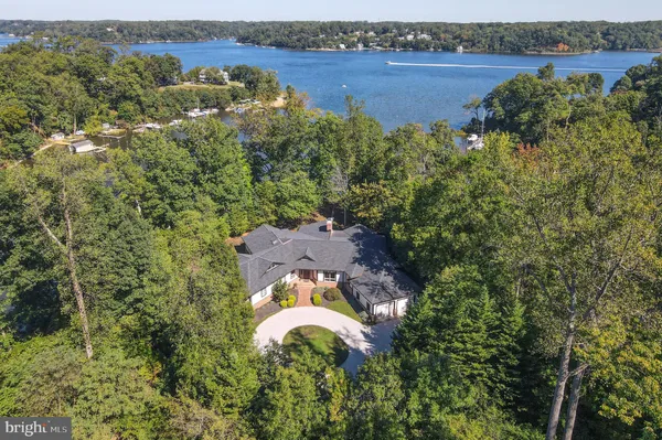 an aerial view of a house with a garden and lake view