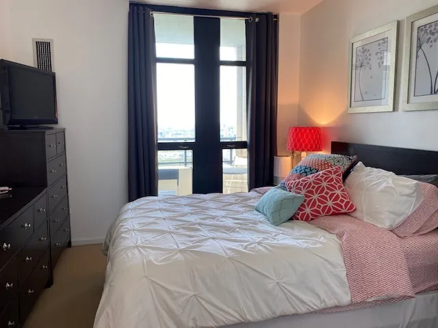 a bedroom with a bed and tv on the dresser