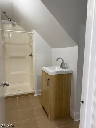 a bathroom with a sink a mirror and shower