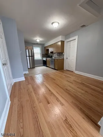 a view of kitchen and hall with wooden floor