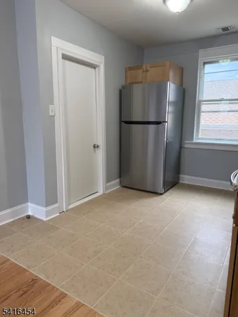 a view of a refrigerator in kitchen and a windows