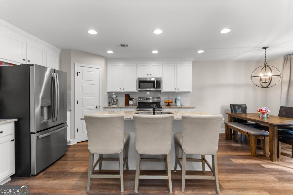 187 Loch Way Eatonton, GA 31024 - Photo 12 of 49 a kitchen with a table chairs refrigerator and microwave
