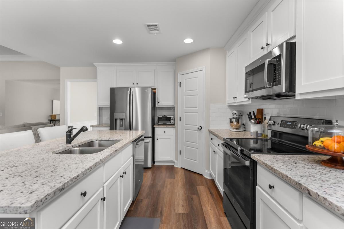 187 Loch Way Eatonton, GA 31024 - Photo 15 of 49 a kitchen with stainless steel appliances granite countertop a sink stove and refrigerator