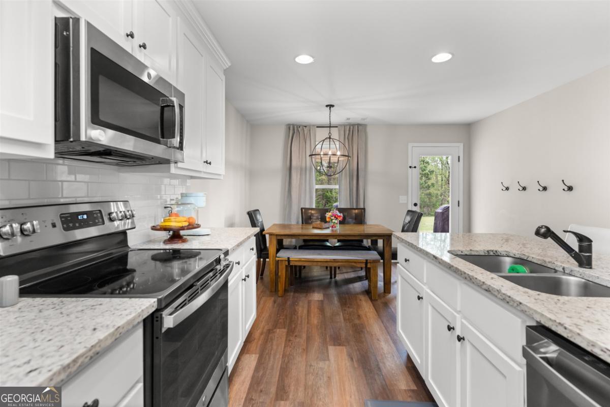 187 Loch Way Eatonton, GA 31024 - Photo 16 of 49 a kitchen with stainless steel appliances granite countertop a sink stove and refrigerator