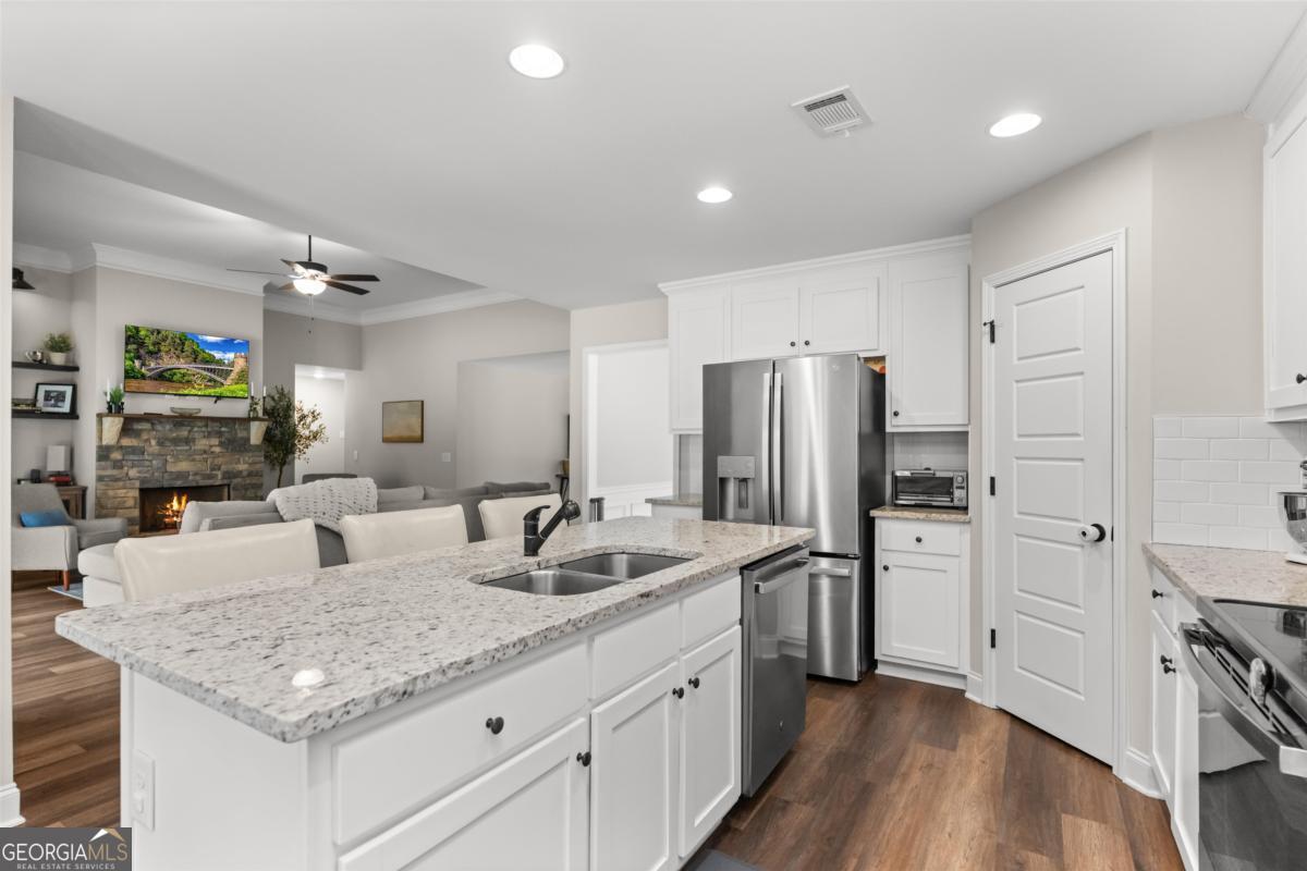 187 Loch Way Eatonton, GA 31024 - Photo 17 of 49 a kitchen with stainless steel appliances granite countertop a sink refrigerator and cabinets