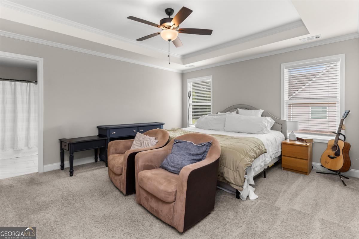 187 Loch Way Eatonton, GA 31024 - Photo 20 of 49 a spacious bedroom with a bed and a chandelier