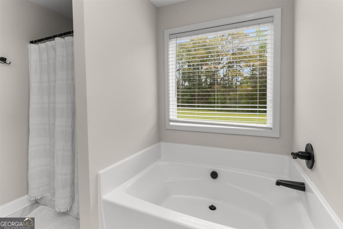 187 Loch Way Eatonton, GA 31024 - Photo 27 of 49 a white bath tub sitting next to a window