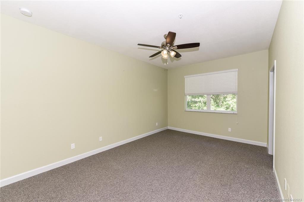 9726 Southwest Purple Martin Way Stuart, FL 34997 - Photo 16 of 30 an empty room with windows and ceiling fan