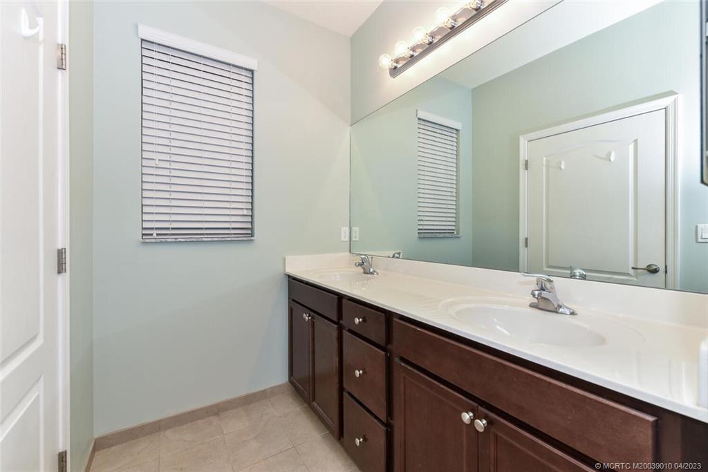 9726 Southwest Purple Martin Way Stuart, FL 34997 - Photo 19 of 30 a bathroom with a double vanity sink and a mirror