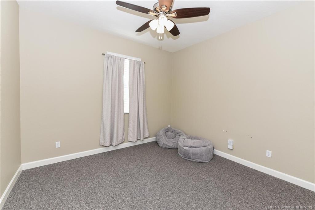 9726 Southwest Purple Martin Way Stuart, FL 34997 - Photo 20 of 30 a view of a room with a fan and a ceiling fan