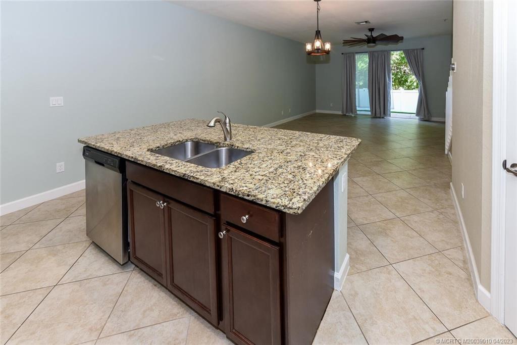 9726 Southwest Purple Martin Way Stuart, FL 34997 - Photo 8 of 30 a kitchen with a sink a counter top space and chandelier