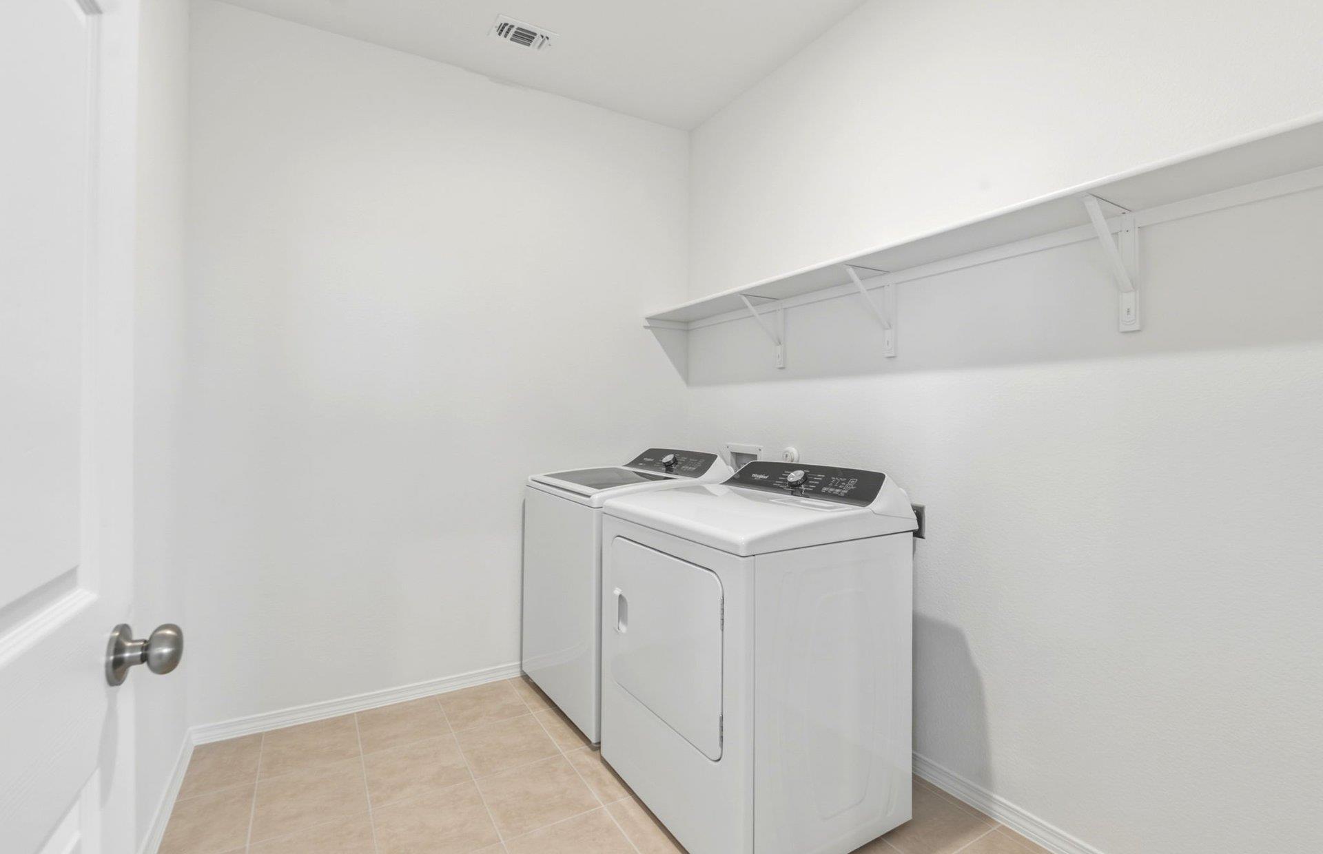 545 Henry Milton Road Georgetown, TX 78626 - Photo 9 of 33 Tiled flooring and a long storage shelf organize this dedicated laundry space.