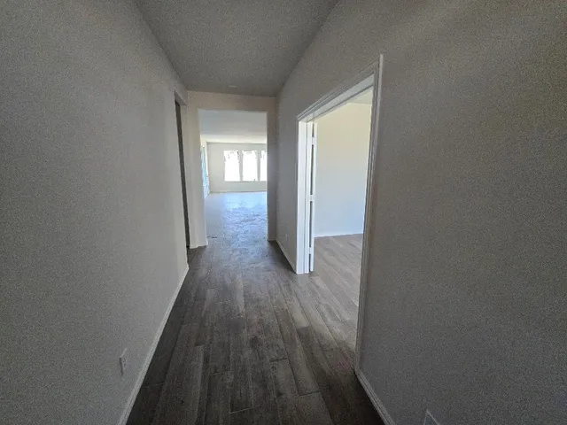 a view of a hallway with wooden floor