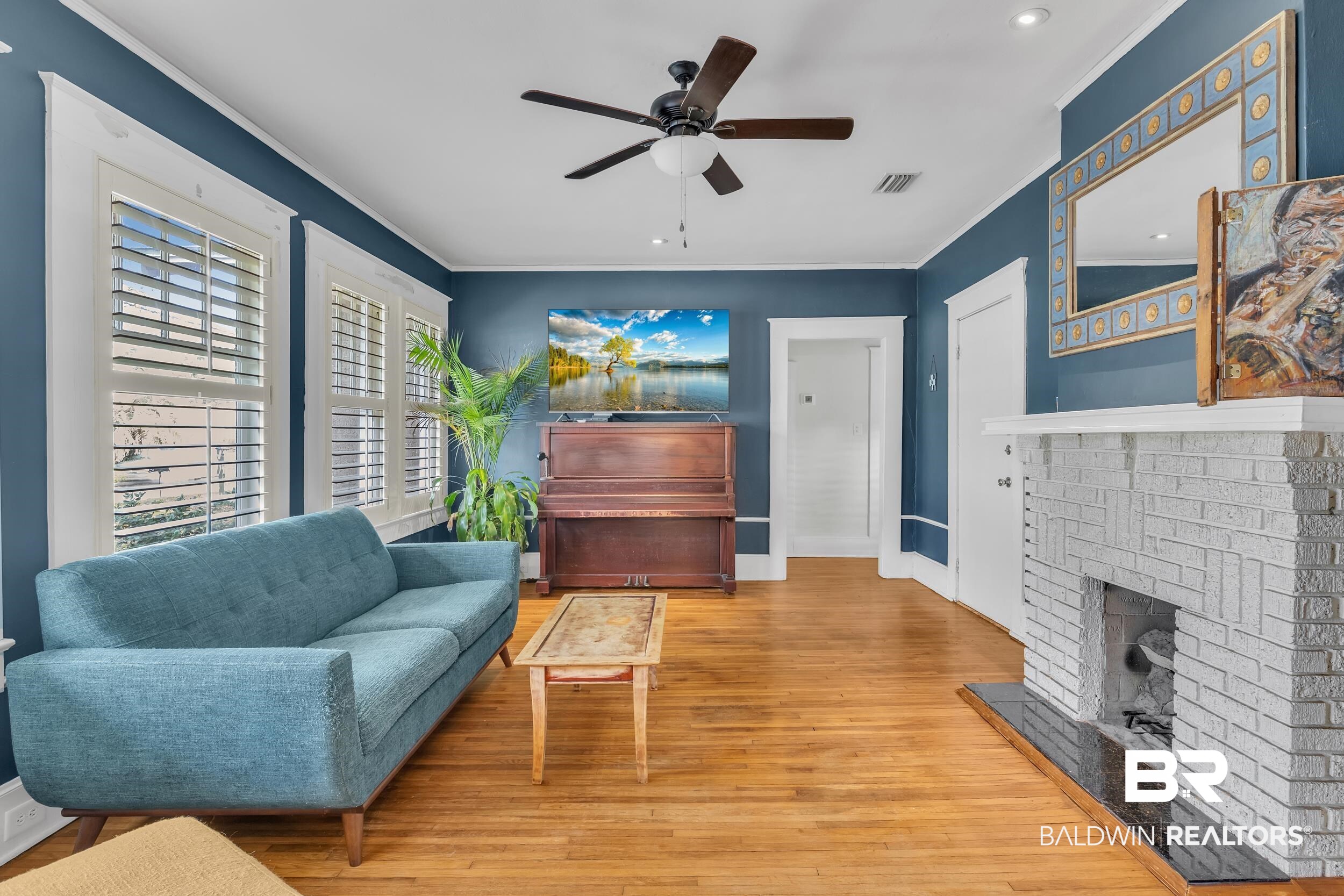 55 Mohawk Street Mobile, AL 36606 - Photo 16 of 28 Living room featuring crown molding, wood finished floors, a fireplace, and visible vents