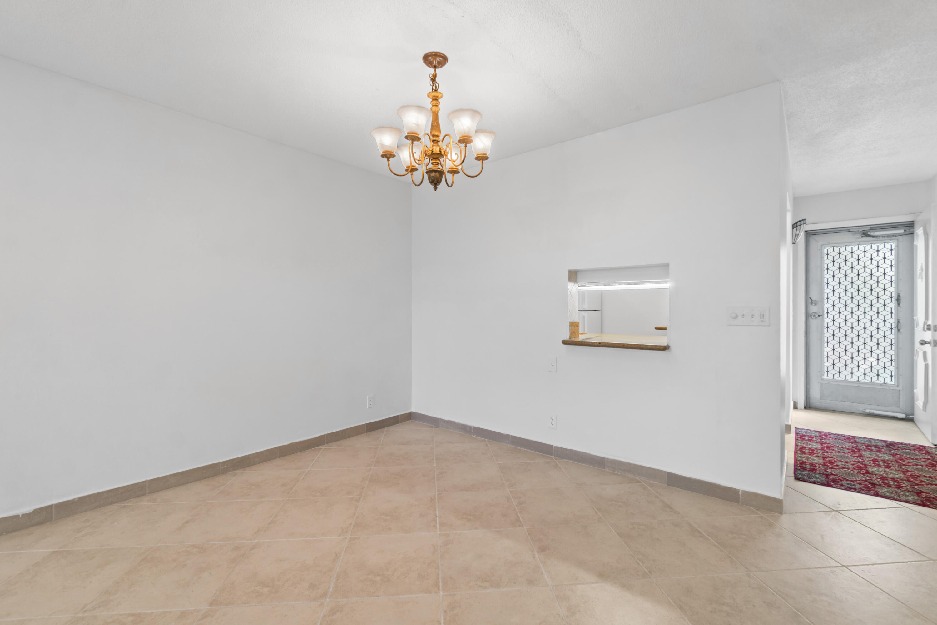 2615 Northeast 1st Court, Unit 303 Boynton Beach, FL 33435 - Photo 17 of 42 an empty room with a chandelier