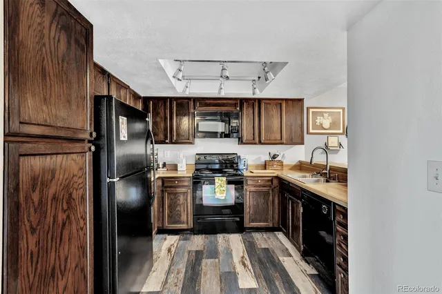 a kitchen with stainless steel appliances granite countertop a sink a stove and cabinets