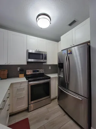 a kitchen with stainless steel appliances a refrigerator stove and microwave