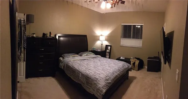 a bedroom with a bed and dresser with mirror