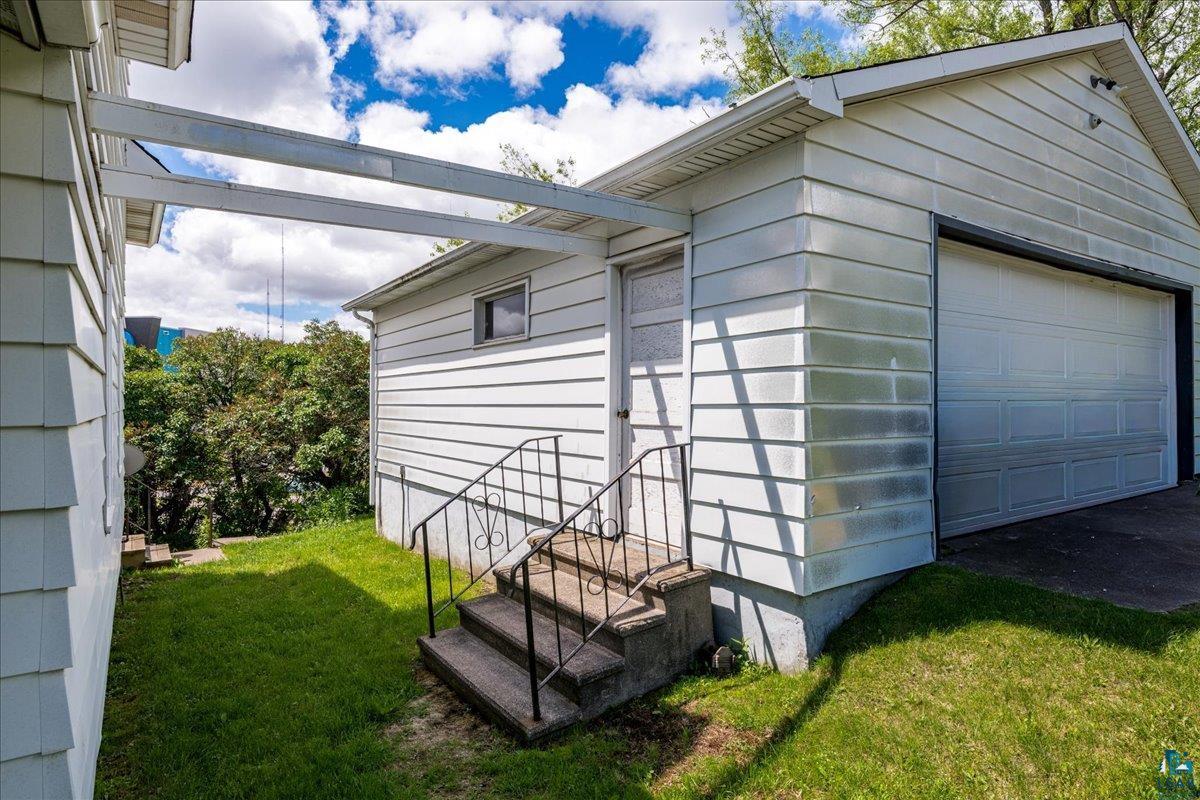 424 East Upham Road Duluth, MN 55811 - Photo 29 of 38 Detached garage with horizontal siding, a paneled overhead door, and a separate side entry