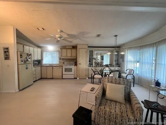 a living room with furniture and kitchen view