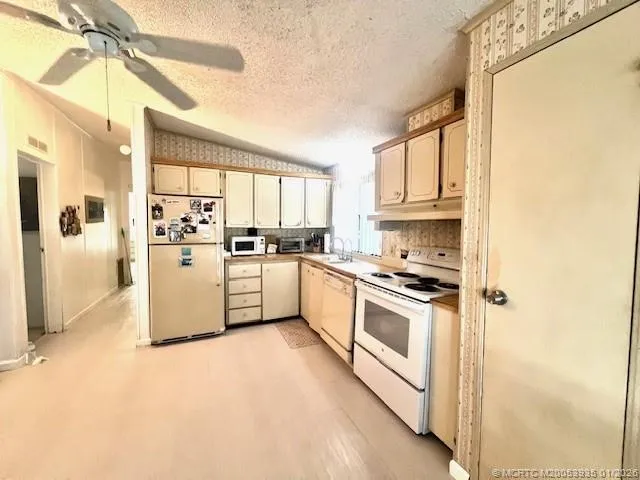 a kitchen with white cabinets and white appliances
