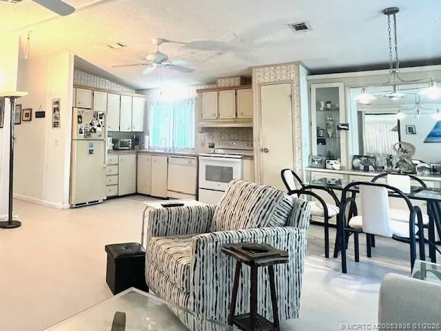 a kitchen with stainless steel appliances kitchen island granite countertop a table and chairs in it
