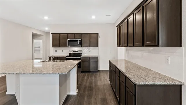 a kitchen with granite countertop stainless steel appliances and wooden cabinets