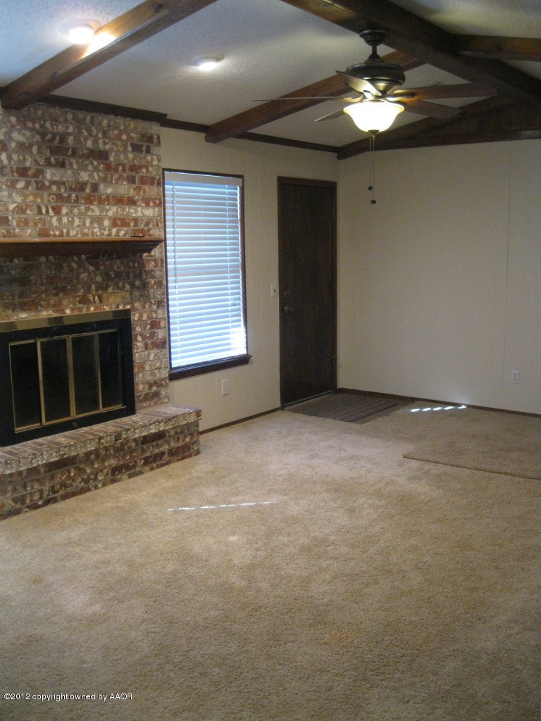 5714 South Milam Street Amarillo, TX 79110 - Photo 4 of 22 a view of an empty room with a fireplace and chandelier fan