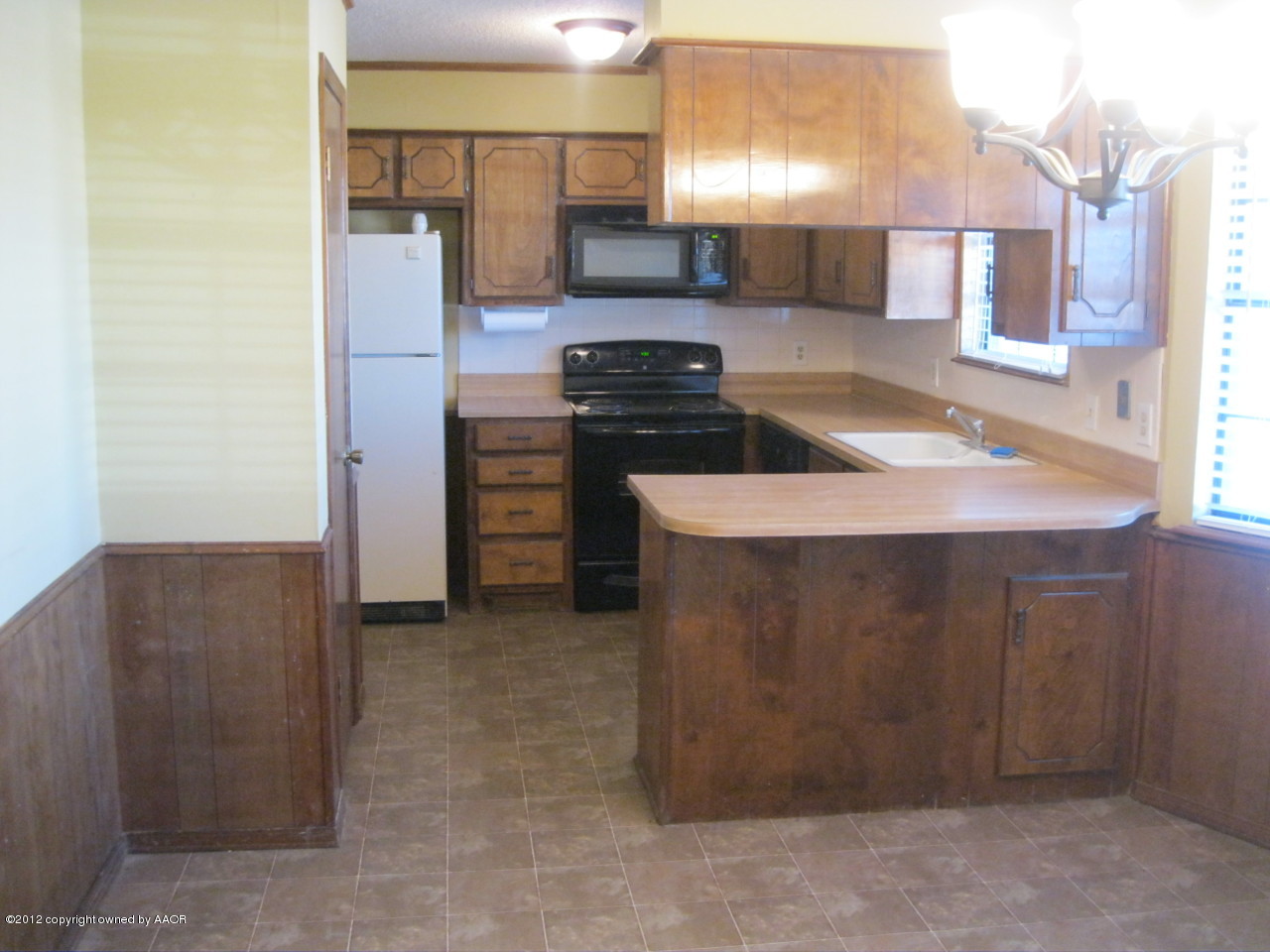 5714 South Milam Street Amarillo, TX 79110 - Photo 5 of 22 a kitchen with a refrigerator and a stove