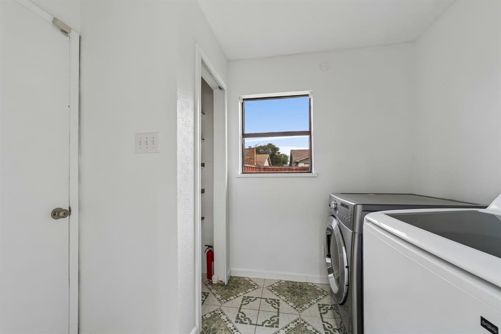 10239 Green Ash Road Dallas, TX 75243 - Photo 14 of 36 Utility room featuring a window, patterned floor tile, and a storage closet with shelving