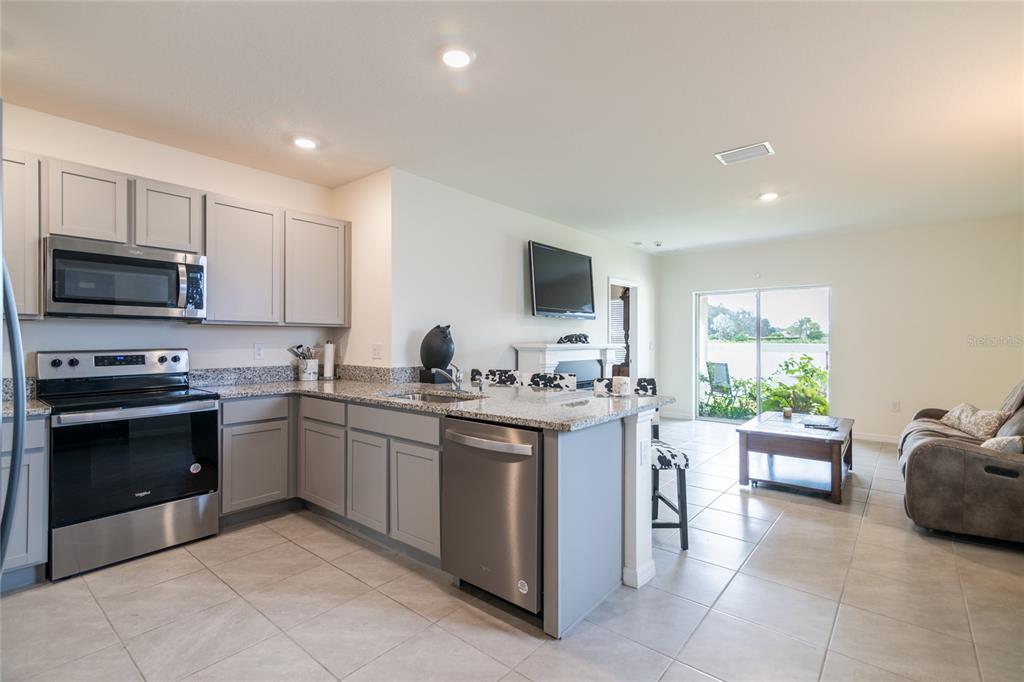 33860 Jasmine Star Loop Wesley Chapel, FL 33543 - Photo 2 of 14 a kitchen with a stove a sink and a microwave