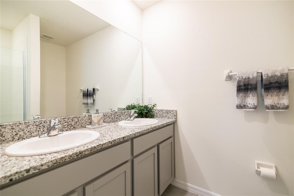 33860 Jasmine Star Loop Wesley Chapel, FL 33543 - Photo 5 of 14 a bathroom with a granite countertop sink and a mirror