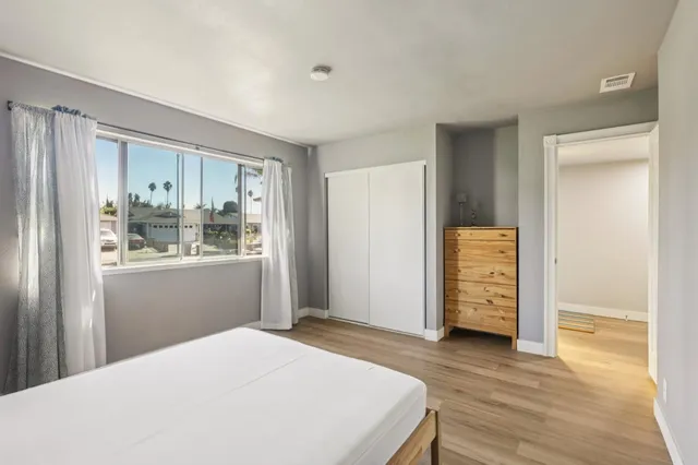 a bedroom with a bed and wooden floor
