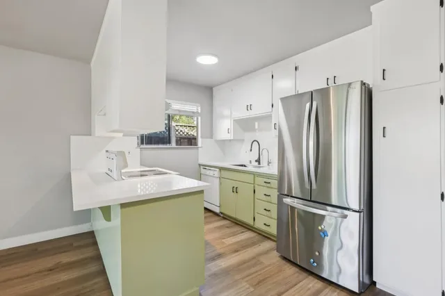 a kitchen with a refrigerator sink and cabinets