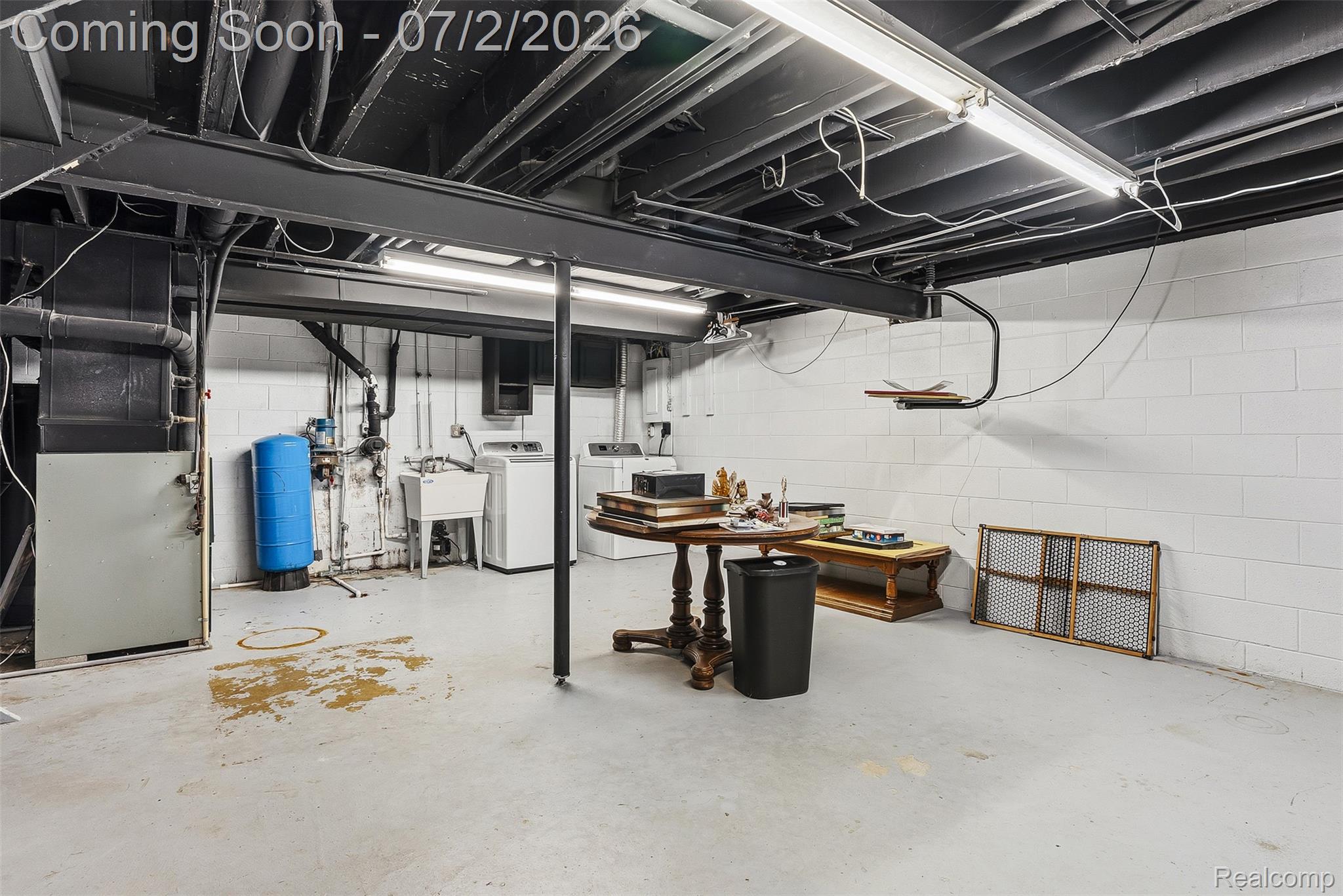 305 East Road Holly, MI 48442 - Photo 27 of 41 Spacious unfinished basement featuring exposed ceiling joists, concrete block walls, and a concrete floor