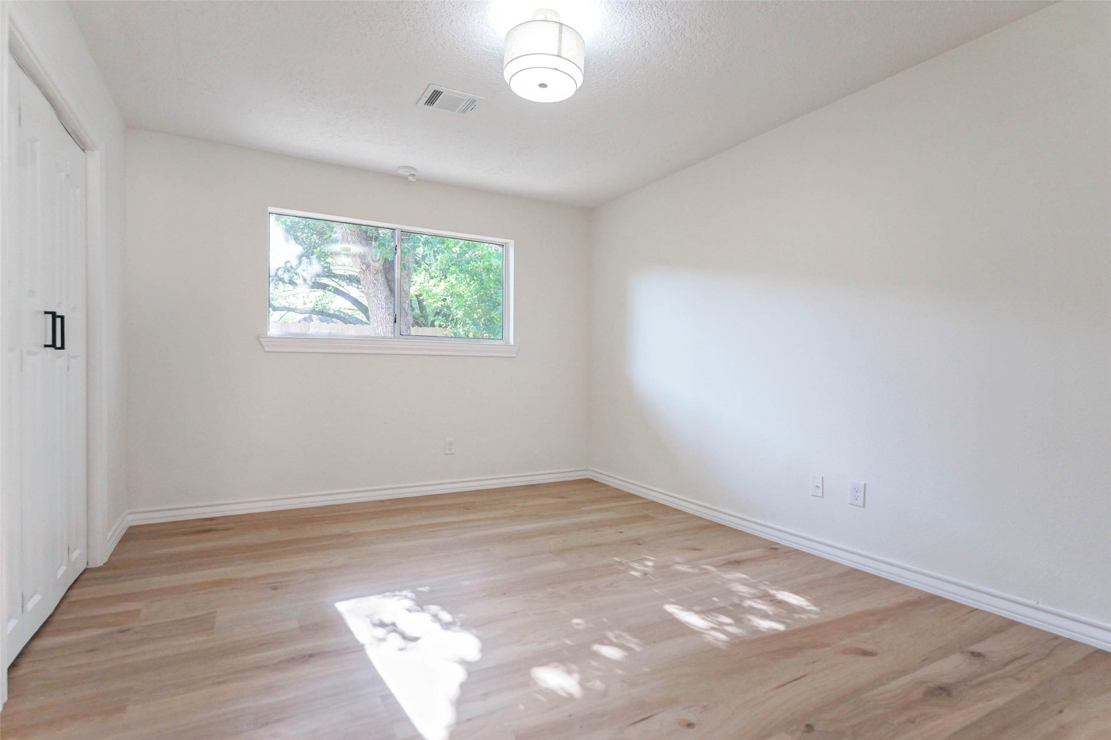 11618 Lakeside Pl Drive Houston, TX 77077 - Photo 11 of 25 an empty room with wooden floor and windows