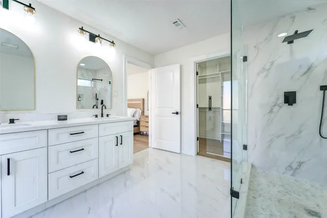 a spacious bathroom with a double vanity sink mirror and shower