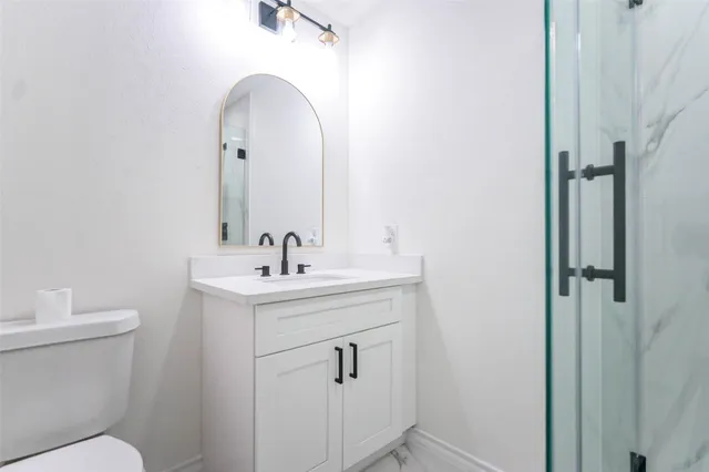 a bathroom with a sink a toilet and a mirror