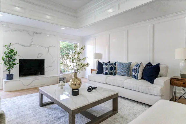 a living room with furniture a flat screen tv and a fireplace